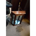 A wall mounted stained beech glazed hanging cabinet with two glass shelves.