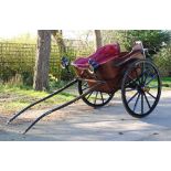 A late 19th century horse drawn open carriage with twin wooden wheels, leatherette upholstery,