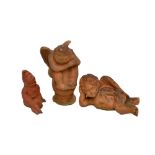 A terracotta glazed figure of a cherub, a similar smaller example and a figure of a gnome (3).