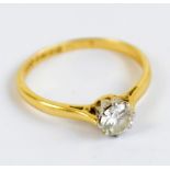 An 18ct yellow gold diamond solitaire ring with brilliant cut stone, and pierced shoulders,