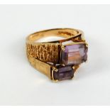 A 9ct yellow gold and emerald cut amethyst double offset stone ring with part textured band, size O,