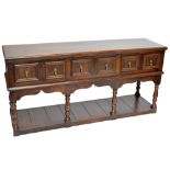 A reproduction oak dresser base with rounded rectangular top above three moulded drawers,