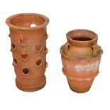 A terracotta glazed strawberry pot with various lipped apertures,