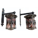 A pair of external wall mounted cast iron lanterns decorated with Fleur de Lis motifs,