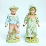 A pair of German Gebruder Heubach figures of a boy and girl skipping (skipping ropes missing),