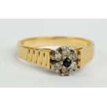 An 18ct yellow gold cluster ring, the central sapphire surrounded by six faceted small diamonds,