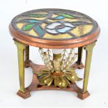 An Arts and Crafts copper and brass table lamp with circular floral decorated leaded stained glass