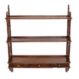 An early 20th century mahogany three shelf wall unit with three geometrically carved drawers,