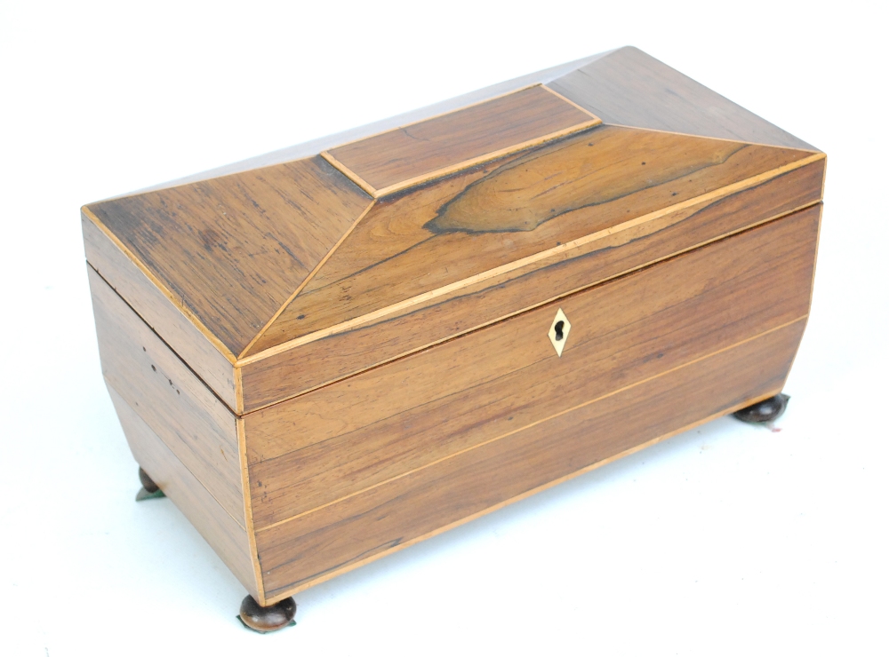 A 19th century rosewood sarcophagus shaped tea caddy on bun feet,