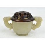 An 18th/19th century Chinese carved pale celadon green jade cup with twin handles modelled as