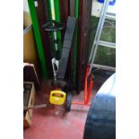 A collection of garden tools including an electric hedge clipper, a folding platform workstation,