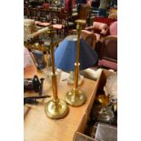 A pair of brass table lamps with circular bases.