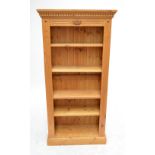 A modern pine open bookcase with four adjustable shelves.