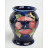 MOORCROFT; A "Pansy" pattern tube lined decorated baluster vase on blue ground,