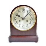 An early 20th century mahogany dome top mantel clock with silvered dial set with Arabic numerals,