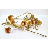 Brass lamp fittings with amber coloured rose shaped glass shades, decorated with a cherub,