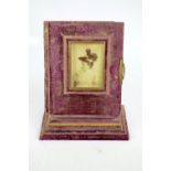 A Victorian purple velvet bound photo album on stepped rectangular stand containing various