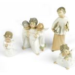 Three Lladro ceramic cherubic figures and a Nao example depicting an altar boy (4).