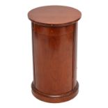 A reproduction cylinder bedside cabinet, lacking handles.