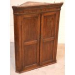 A 19th century oak wall corner cupboard with panel doors and two interior shelves, height 101cm.