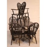 An oak dining table and set of six wheel-back elbow chairs (7).