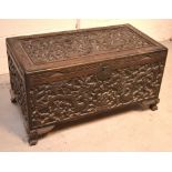 A Chinese profusely carved camphorwood blanket chest with hinged lid, width 106cm.