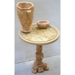 A composite ivory-effect circular side table with ornately carved top of figures in horse and cart,