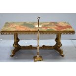 An onyx and brass coffee table on brass supports and cross-stretcher,