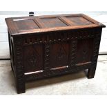 An 18th century oak three-panel coffer with hinged lid above carved front, width 101cm.