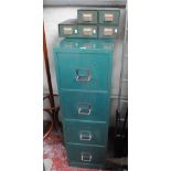 A four drawer metal filing cabinet and several small desk banks of drawers.