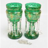 A pair of late Victorian green glass table lustres with painted floral and gilt heightened