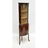 A reproduction mahogany bowfronted freestanding corner cupboard with glazed upper section.