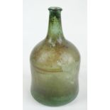 A large 18th century green glass wine bottle with waisted body and conical bottom, height 41cm.