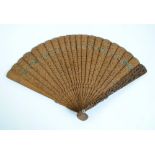 An early 20th century Chinese carved sandalwood brisé fan decorated with figural and architectural