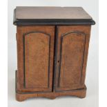 A Victorian burr walnut desk cabinet with two panelled hinged doors enclosing three drawers,