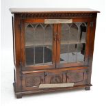 A reproduction oak bookcase with leaded glazed upper doors and twin cupboard doors beneath,