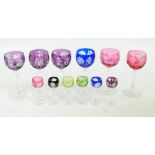 A set of variously coloured cut crystal hock glasses,