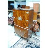 A mahogany cocktail cabinet with ornate brass work, on cabriole legs.