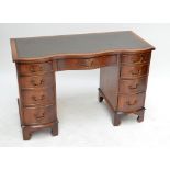 A reproduction mahogany serpentine outlined nine drawer kneehole desk, width 105cm.