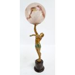 An Art Deco painted spelter figural lamp base modelled as a semi nude dancer holding a globular