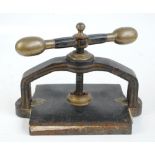 A late 19th century cast iron table top book press with brass fittings and manufacturer's label