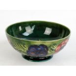 MOORCROFT; an 'Anemone' pattern tube line decorated circular bowl on green ground signed in blue,