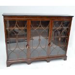 A reproduction mahogany three door glazed bookcase raised on bracket feet, width 168cm.