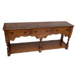 A reproduction oak dresser base, the moulded rectangular top above three frieze drawers,