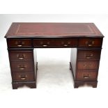 A reproduction mahogany leather inset twin pedestal desk with serpentine moulded top, width 120cm.