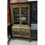 A 1930s oak glazed display cabinet.