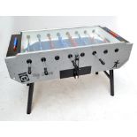 A Heemskerk table football game with blue and red figures and integral metal stand.