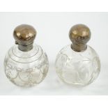 Two similar early 20th century globular and clear glass and silver mounted scent bottles (both af,