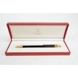 A boxed Must de Cartier ball point pen with black body, numbered 304842.