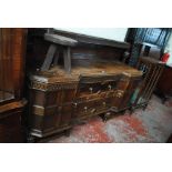 A 1920s/30s oak inverted breakfront sideboard with raised back, on lobed and block feet,